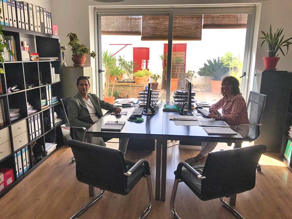 Oficina de Técnica y Arquitectura Azuaga Oficina de Técnica y Arquitectura con dos profesionales frente al ordenador.